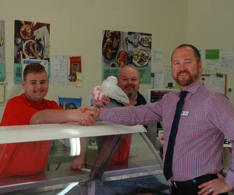 A GOOD MEATING: Brendan Hodges, employer Anthony Blake and high school principal Michael Gibson shake hands at Brendan's new work place. Photo: GRACE RYAN. 