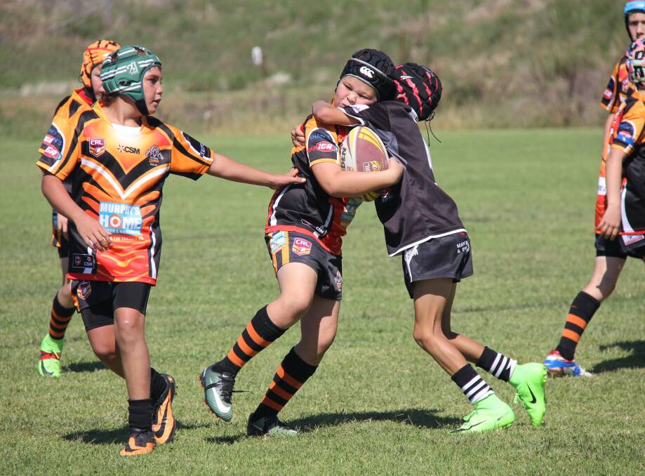 JUNIOR LEAGUE: Nyngan Tigers under-11s' Jet Besant takes on the defence.