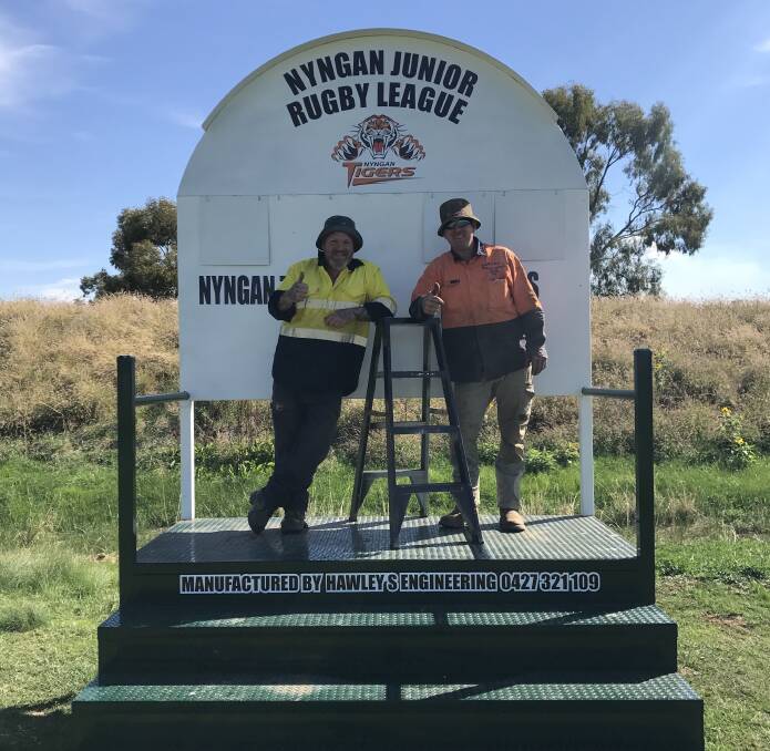 Local legends Wozza & Fitz add the finishing touches to the new "Hawleys Engineering Built" Scoreboard at the junior league oval.