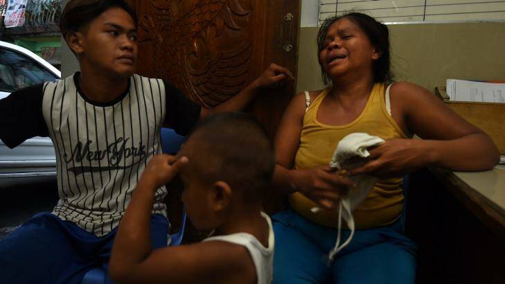 A neighbour comforts Ruth-Jane Sombrio at the funeral home where her husband is being held in Binondo District, Manila.  Photo: Kate Geraghty