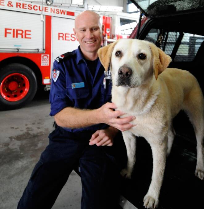 NSW Fire and Rescue canine handler Tim Garrett and Sheba, a nine-year-old Labrador, who investigate fires across NSW. 	Photo: LOUISE DONGES 