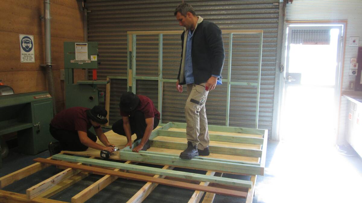 o TAFE Construction teacher, Mark Penman guides two Lincoln School students through the construction of the cubby house that will raise funds for breast cancer support. 