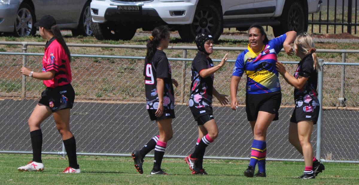 TRY TIME: Michelle Blake (headgear) congratulates Majayda Darcy on her first of three tries in the Goannas' big grand final win over Panorama. 