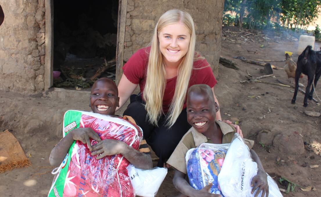 ALL SMILES: Anna Carter volunteers her time in Uganda with ‘Life Charity Focus’ and Joy Blessed Nursery and Primary school. Photo: CONTRIBUTED