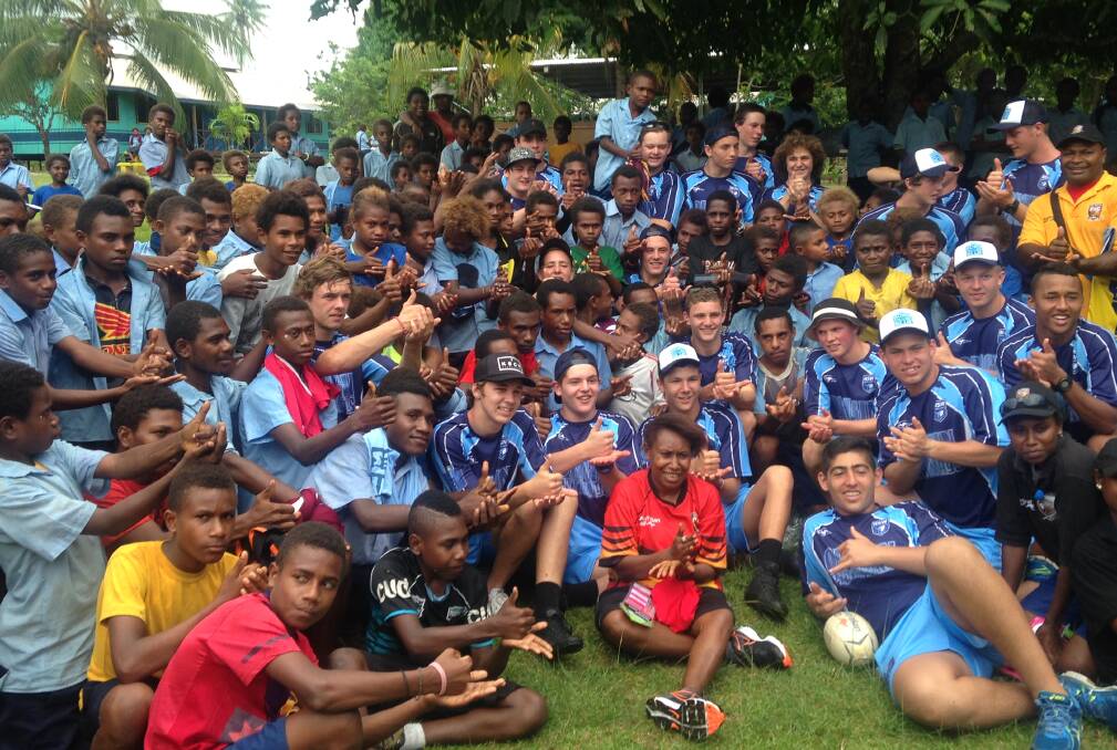 LOVE OF THE GAME: NSW Young Achievers players with locals during a tour of Papua New Guinea in recent years. Photo: CONTRIBUTED