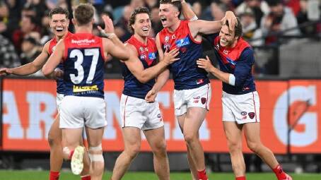 Melbourne's Daniel Turner (2nd right) celebrates a goal with teammates against Richmond. (James Ross/AAP PHOTOS)