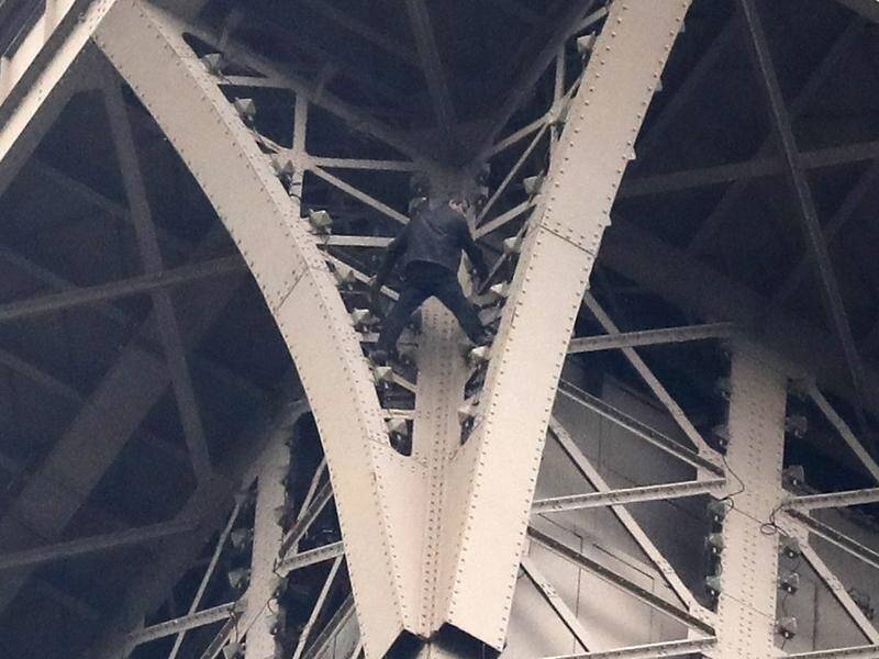Rescuers have managed to talk down a man who scaled the Eiffel Tower.