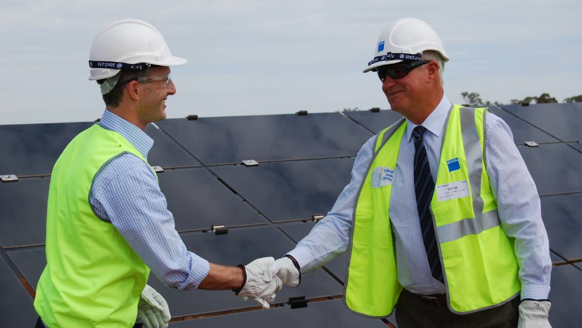 o AGL managing director Andy Vesey and Energy Minister Anthony Roberts installing the final panel at the Nyngan Solar Plant on Friday.