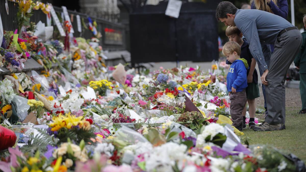 Mourners lay flowers on a wall at the Botanical Gardens in Christchurch, New Zealand, after a mass shooting at a mosque perpetrated by an Australian man. Picture: AP